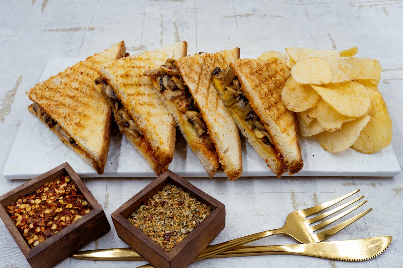 Savor this gourmet grilled mushroom sandwich served with crispy chips, perfect for a tasty meal.