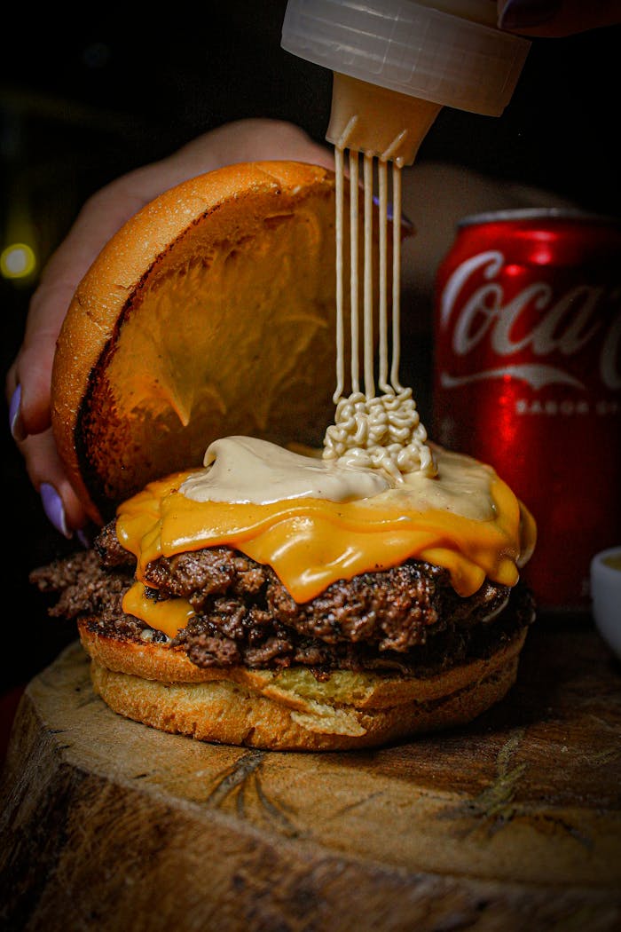 Delicious gourmet burger topped with melted cheese and served with a soft drink, captured in Brazil.