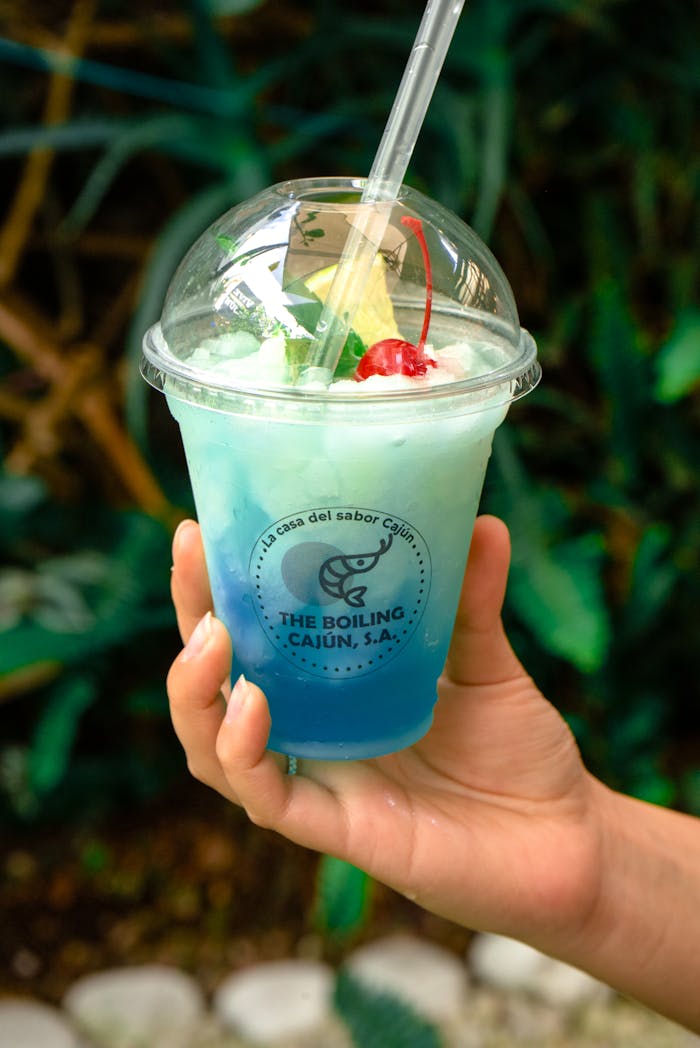 The Art of Drawing Readers In: Your attractive post title goes here A vibrant blue tropical drink in a branded cup with cherry garnish, perfect for summer refreshments.